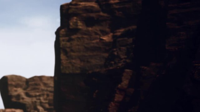 Groups of individuals are seen climbing a rocky cliff during the day. The bright sky highlights the rugged landscape. This activity shows teamwork and skill in a natural setting.