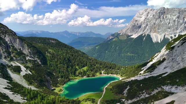 Aerial drone view of the Alps and the green Seebensee on a sunny summer day. A couple enjoys the view of Seebensee and goes hiking. Seebenlake	