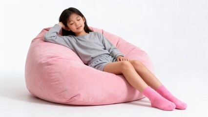 Fototapeta premium Young girl resting on pink beanbag