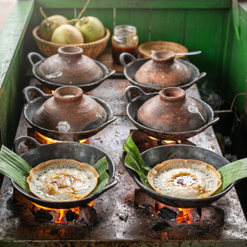 Hand Pouring Sweet Palm Sugar Sauce on Serabi, Indonesian Traditional Green Pandan and Coconut Pancakes, Drizzling Kinca Syrup on Rice Cake, Bright Cream Background Food Photography