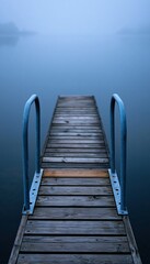 Fototapeta premium Dock ladder extending into calm glassy lake with empty sky above