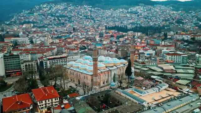 Bursa Ulu Cami panoramic city view during a cinematic drone flight over the historic center. Aerial tourism and travel landmark concept in Turkey.