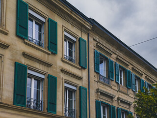 Fototapeta premium Architectural detail of a historic building facade with green shutters and decorative windows in Romont, Canton of Fribourg, Switzerland, photographed on June 11, 2026.