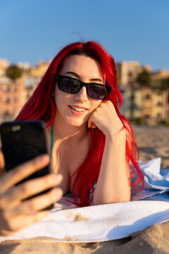 Young woman taking a selfie on the beach, enjoying vacation and summer lifestyle
