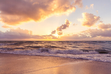 Obraz premium Beautiful cloud coastline background. Fiery orange sunset sky. Amazing sunrise on the beach in Miami. Orange tone