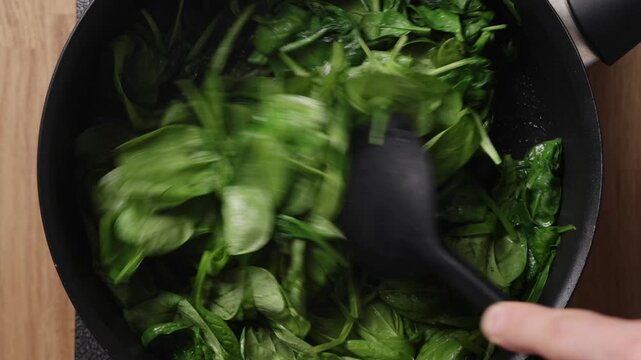 Stirring Fresh Spinach In Pan Top View