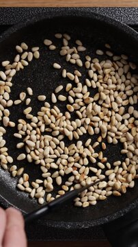 Toasting Pine Nuts In Pan Top View Vertical