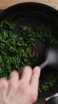 Wilting Fresh Spinach In Pan Top View Vertical