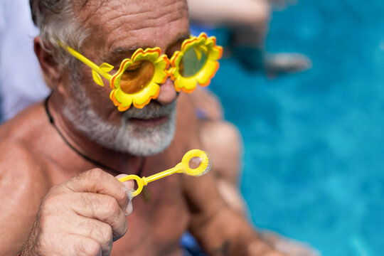 Elderly man enjoying summer poolside.