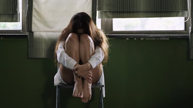 Unhappy Asian young woman sitting alone feeling sad lonely depressed worried upset in her room at home. The problem of female stress and waiting for mental health. Depression and loneliness concept. 