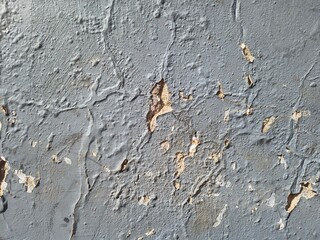 Gray wall texture with peeling paint showing an old distressed concrete surface © Harry