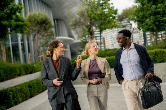 Group of people walking and talking in a city park during the day
