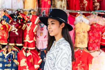 Naklejka premium Woman exploring vibrant traditional market.