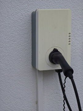 weathered residential wallbox charging station with cable illustrating practical electric vehicle home charging solution
