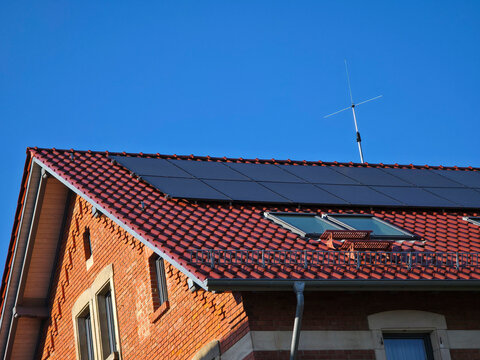 renovated red brick house with modern pv modules blending heritage charm and sustainable innovation beneath blue sky