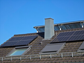 Fototapeta premium pv modules beside roof windows creating efficient renewable energy solution under radiant deep blue sky