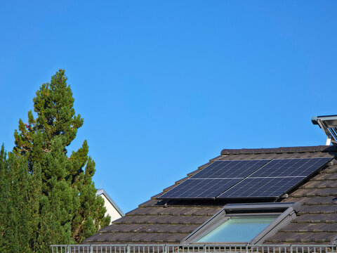 two pv modules on residential roof providing clean renewable electricity beneath vivid deep blue sky