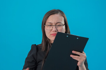Fototapeta premium Woman holding a clipboard and writing notes in a professional studio