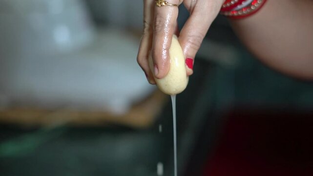 Indian Woman Squeezing Sugar Syrup From Soft Rasgulla Sweet Close Up. Macro Shot of Squeezing Homemade Rasgulla Dessert Ball in an Indian Kitchen.
