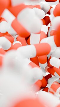 Orange and white capsules falling and filling the screen. 3D animation of medical pills. Pharmacy and healthcare concept. Vertical video.