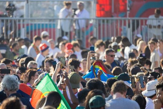 Football fans cheering with flags and phones at large event