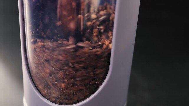 Macro view of roasted coffee beans inside a coffee machine or grinder hopper, highlighting rich textures, warm tones, and shallow depth of field.