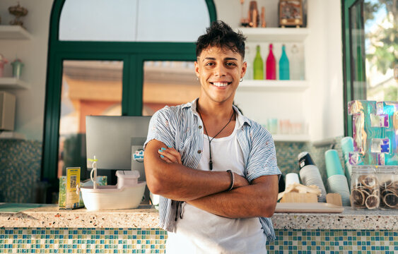 Joyful young man enjoys summer travel, smiling confidently from behind a colorful retail counter