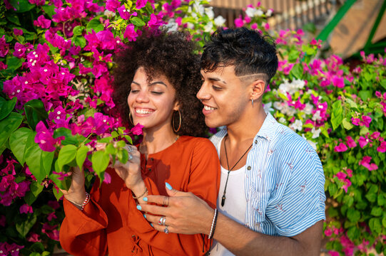 A multicultural couple enjoys a moment of love and connection in a beautiful blooming summer garden