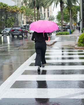 Woman Walking with Pink Umbrella on Rainy City Street