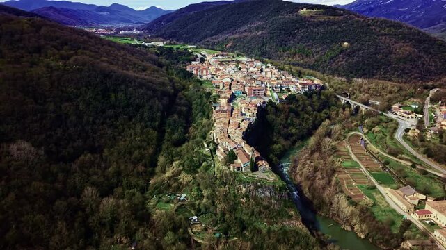 Aerial view of Castellfollit de la Roca village surrounded by mountains and green valley