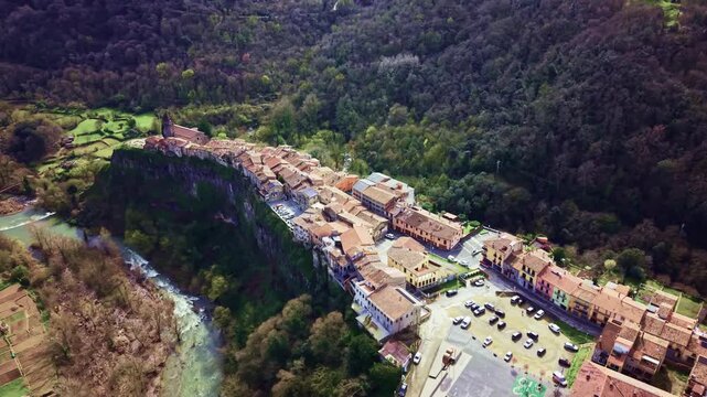 Aerial panorama of Castellfollit de la Roca perched on volcanic cliff in Spain.