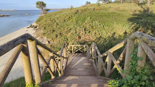 First-person perspective walking down a wooden boardwalk to the beach