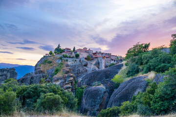 Fototapeta premium Historic monasteries of Meteora perched atop towering sandstone rock pillars in central Greece. Built by Orthodox monks centuries ago, these remarkable religious structures stand dramatically