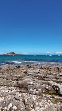 Saint-Michel beach with anchored boats and Ilot Saint-Michel island in Erquy, Brittany, France. 