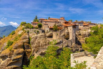 Fototapeta premium Historic monasteries of Meteora perched atop towering sandstone rock pillars in central Greece. Built by Orthodox monks centuries ago, these remarkable religious structures stand dramatically