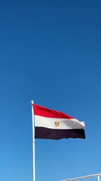 Egyptian flag on a ship against the sky, waving, maritime pride, national symbol, sunny voyage.