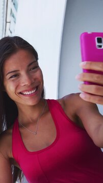 Vertical video of Cruise ship vacation woman taking selfie photo with smart phone camera enjoying travel at sea. Girl using smartphone to take self. Woman in dress on cruise liner.