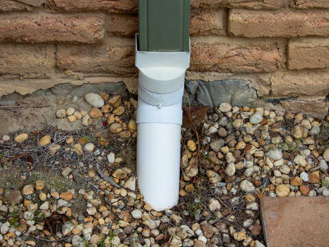 Photograph of an ageing rainwater down pipe and drain on the side wall of a house in the Blue Mountains in New South Wales, Australia