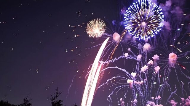Colorful fireworks brighten nighttime sky, Vibrant firework displays erupt across dark night sky, Colorful explosions illuminate night with stunning displays and lively sparkling trails.