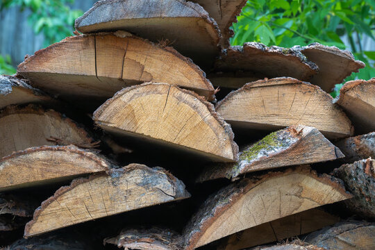 a stack of semi-circular slabs of wood, often referred to as edgings or offcuts, piled together in a sawmill setting