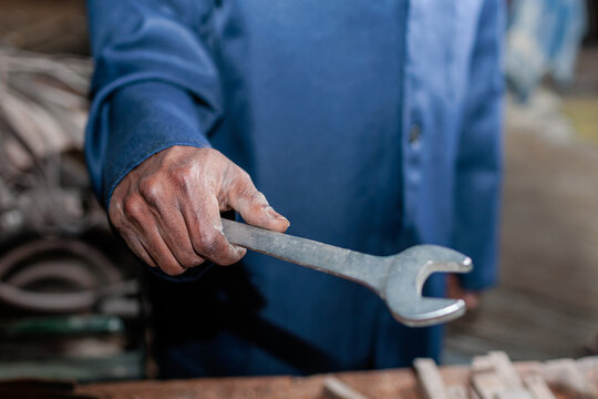 Closeup of worker holding a wrench in a workshop
