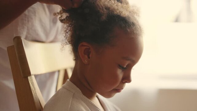Capricious and tired little black girl doing homework, mom helping her, portrait. Emotional child grimacing when has difficulties in education, homeschooling and studying, modern parenting style