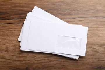 Obraz premium Stack of white envelopes on wooden table, top view