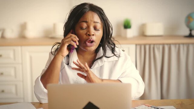 Claim of clients in call-center, adult black woman talking by phone and arguing. Portrait of annoyed and angry african american lady calling to partners, colleagues or service, emotional female person