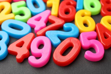 Fototapeta premium Different colorful numbers on black table, closeup