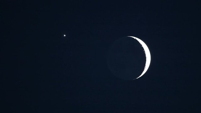 Magnified telescope footage of beautiful astronomical event with moon earthshine and Venus