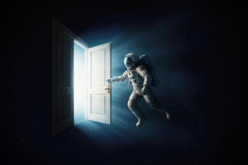An astronaut in front of an open door to another dimension, from which light emerges. © andrey_l