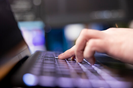 Programmer typing on keyboard, designing and developing software programs, extreme close-up shot. Remote IT employee implementing and maintaining company systems on computer.