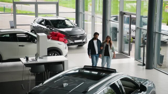 Indian couple walking into a car dealership showroom