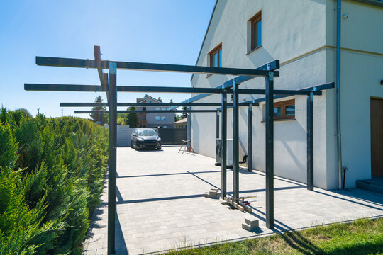 Solar carport construction with steel supports anchored in concrete